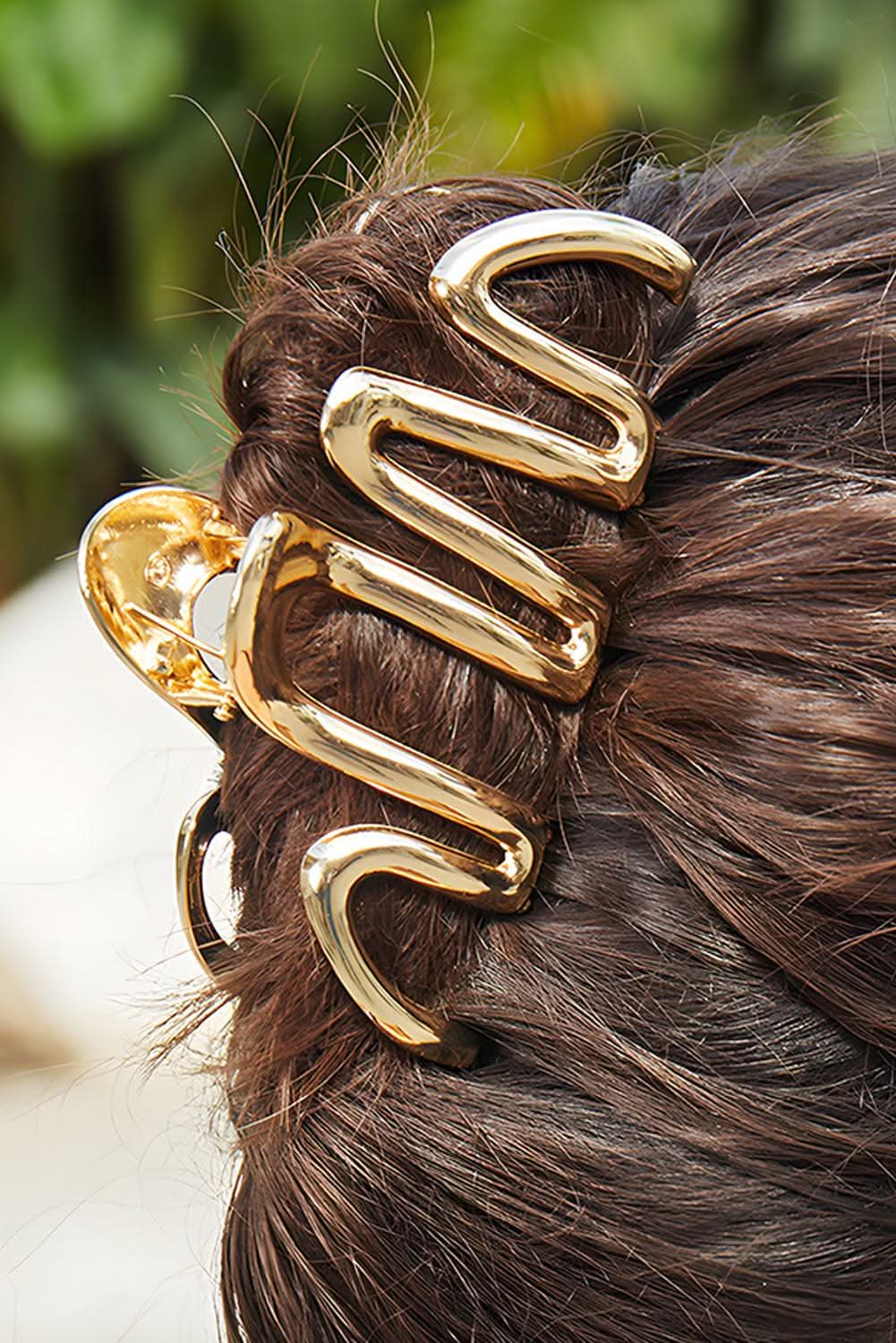 Gold wave shaped large plated alloy hair clip in brown hair