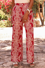Woman wearing red paisley printed high waist straight leg pants with button detail outdoors