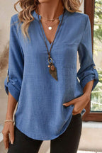 Blue solid color notched V neck blouse with roll-up 3/4 sleeves and front pocket.