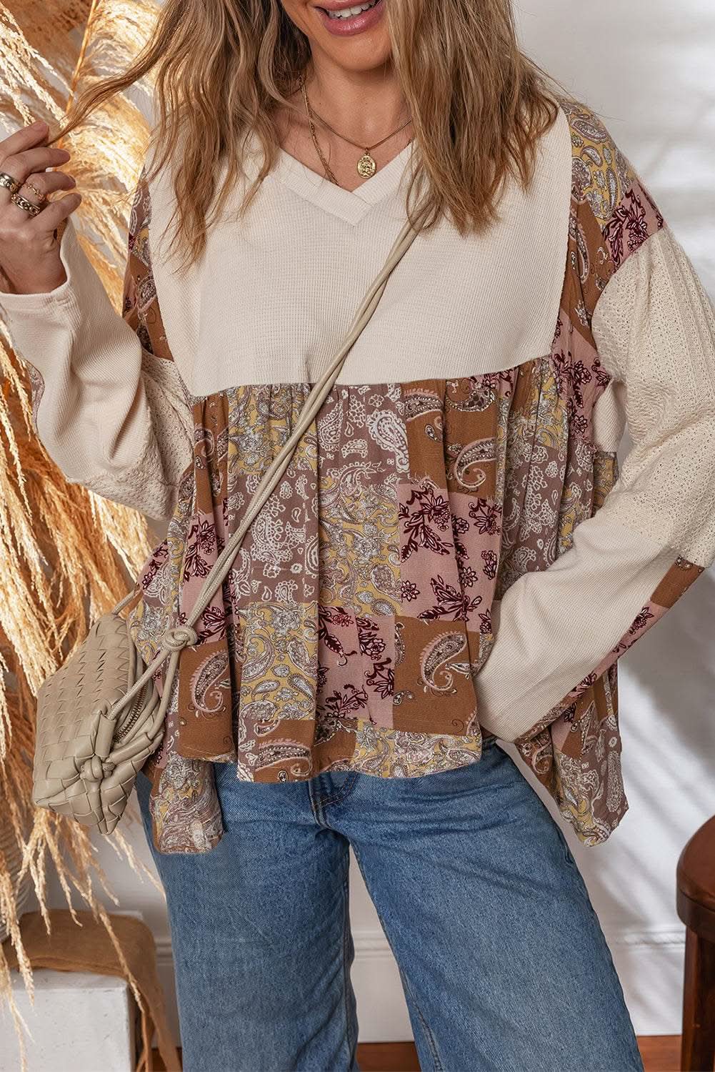 Woman wearing beige paisley ethnic print contrast patchwork long sleeve loose top with handkerchief hem