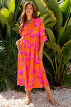 Woman wearing orange floral print frilly smocked V neck 3/4 sleeve long dress outdoors