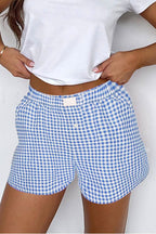 Women's high waist gingham shorts in blue and white with elastic waistband and button fly.