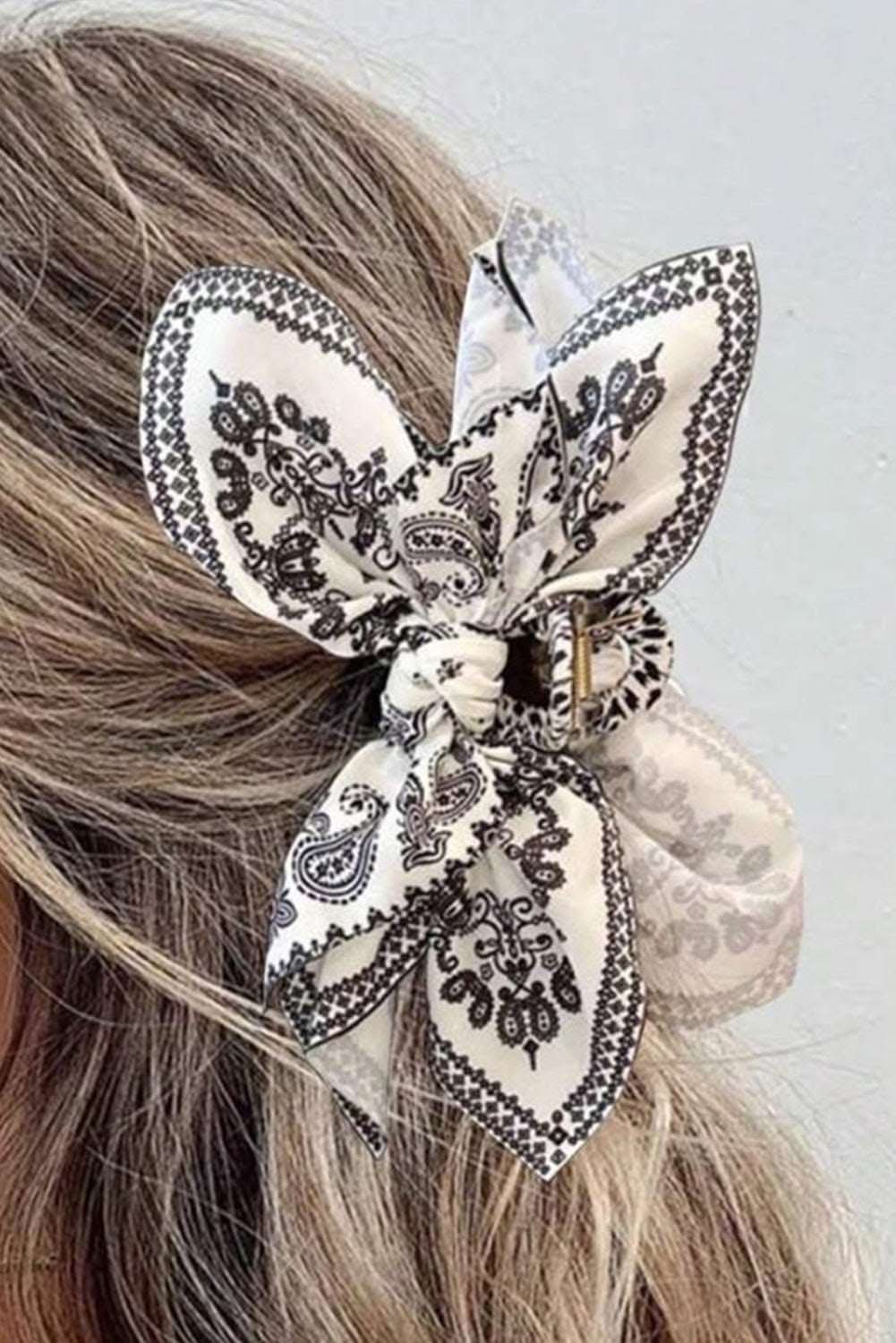Black paisley floral print bow knot hair clip on blonde hair
