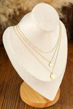 Elegant Gold Multi Layer Disc Pendant Necklace displayed on beige stand