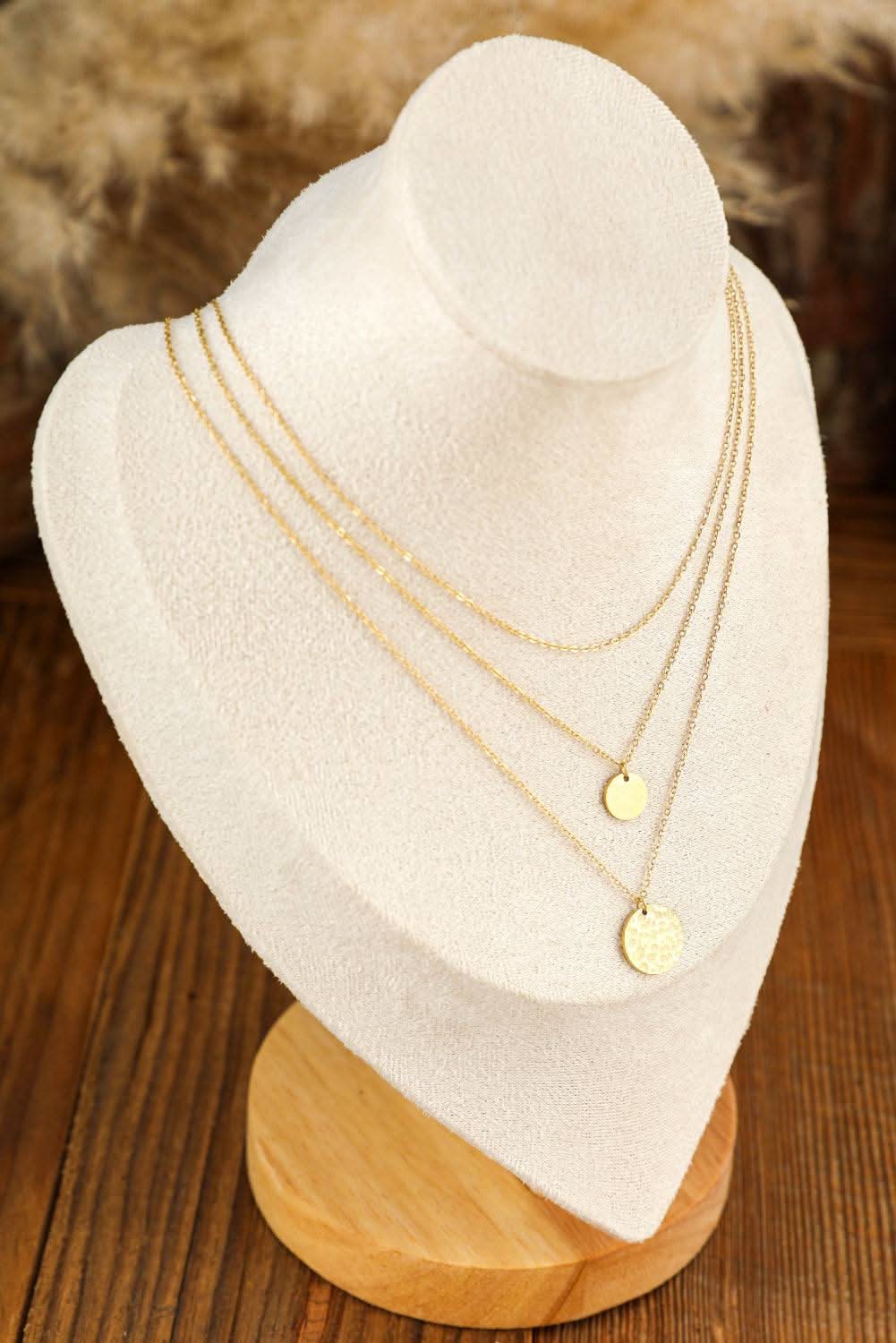 Elegant Gold Multi Layer Disc Pendant Necklace displayed on beige stand