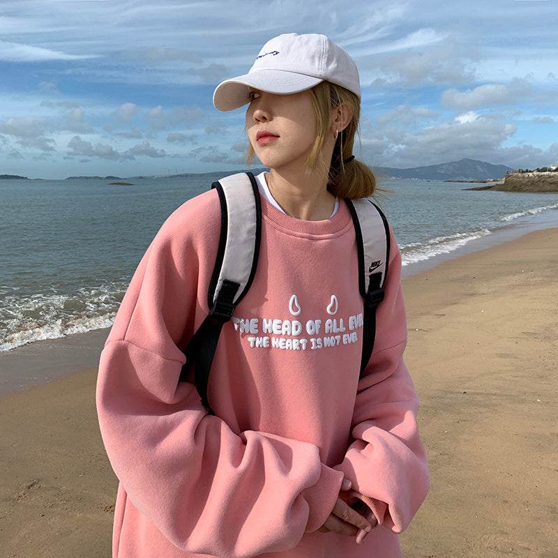 Loose fit pink sweater women with letter print and round neck on beach background