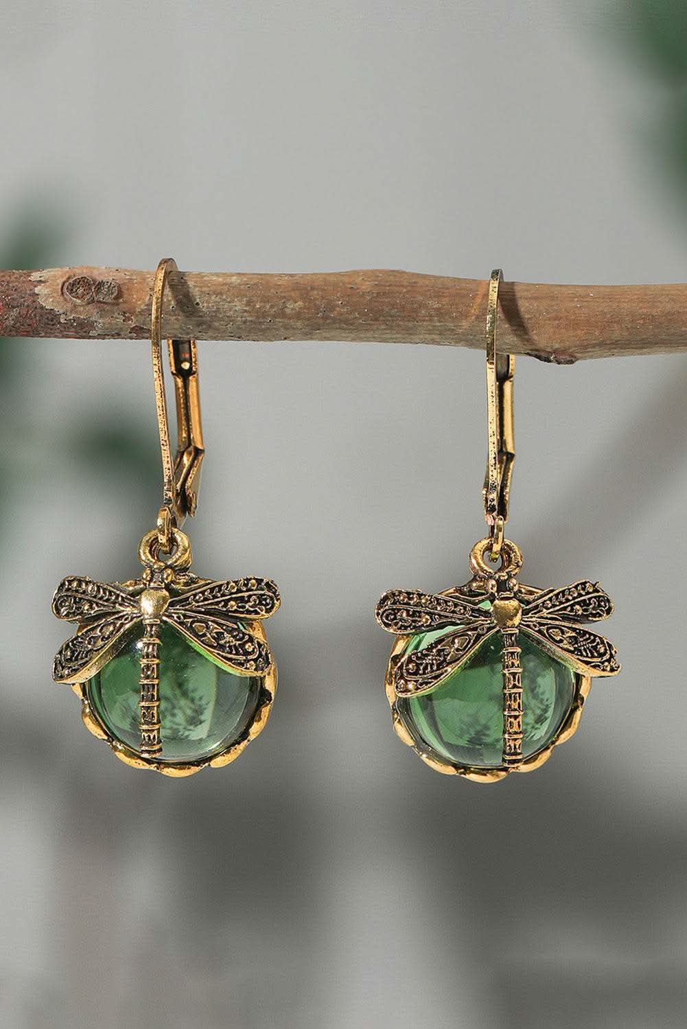 Grass green vintage dragonfly crystal pendant earrings hanging on branch