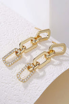 Gold chain link rhinestone decor plate stud earrings on white textured surface