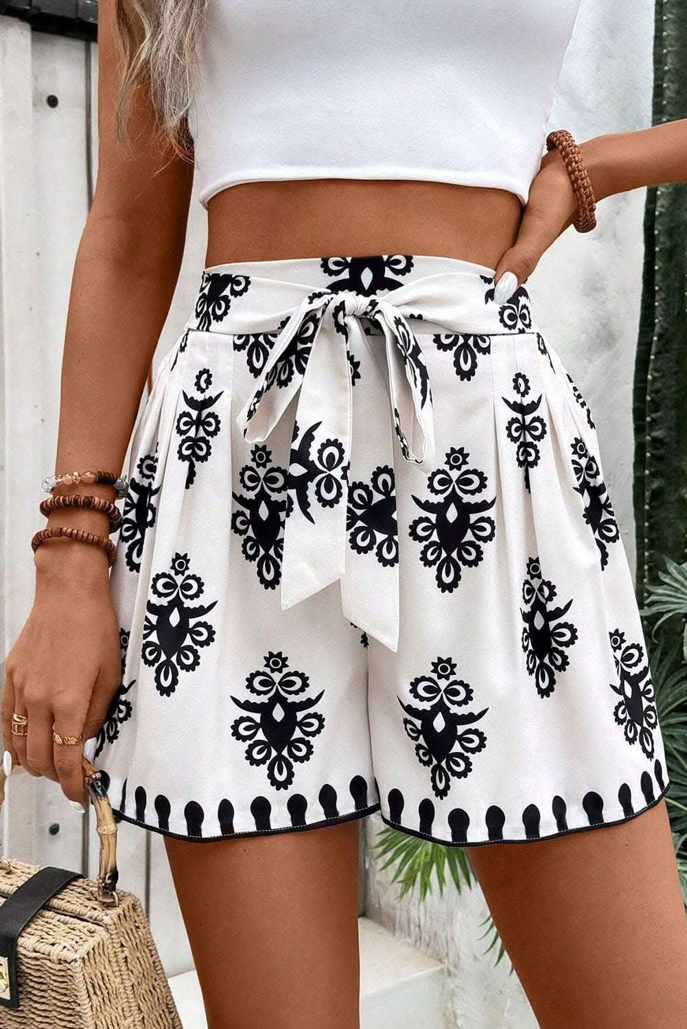 White high waist shorts with black tribal geometric print and belted knot detail.