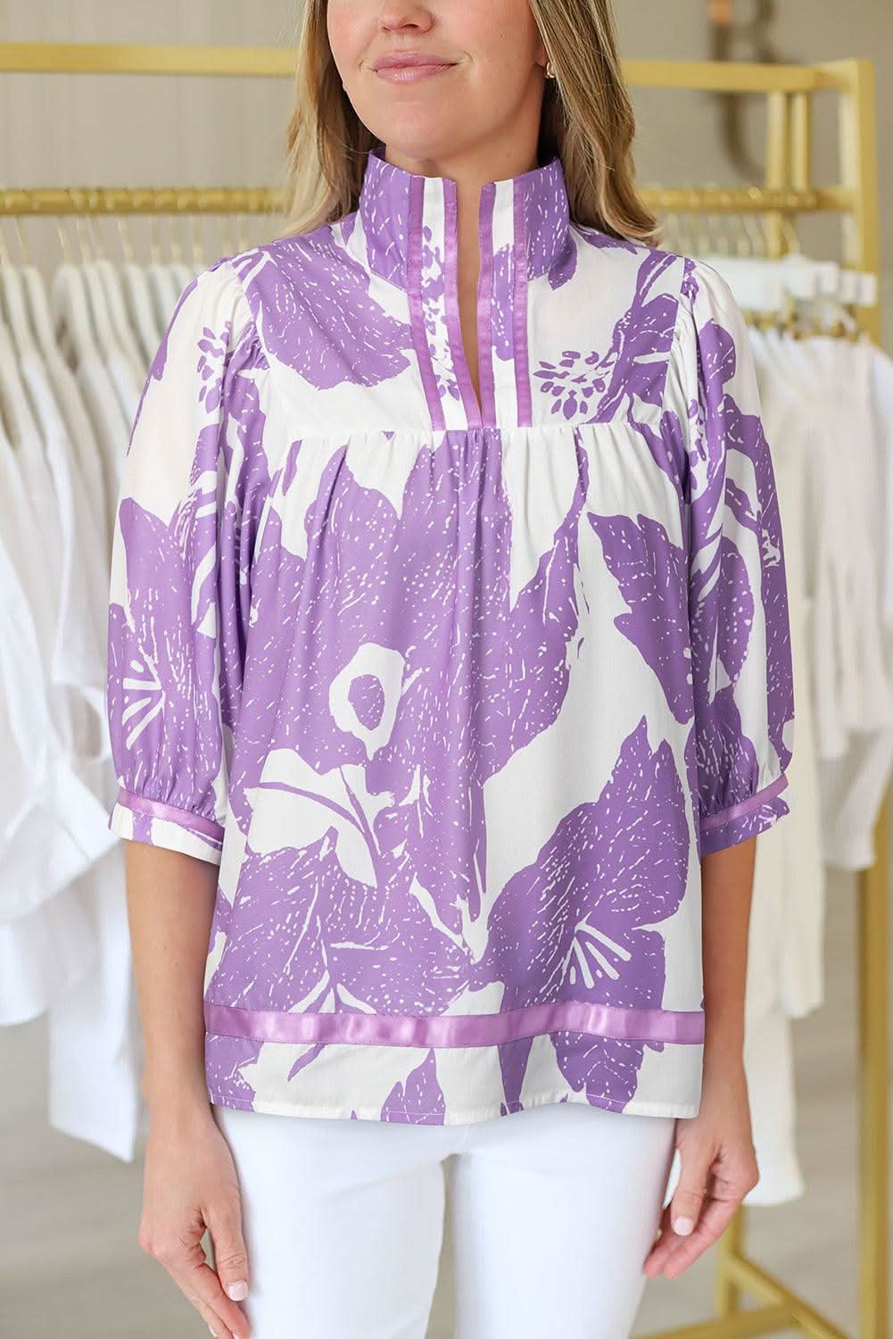 Purple leafy print blouse with 3/4 sleeves, split neck, and striped trim detail.