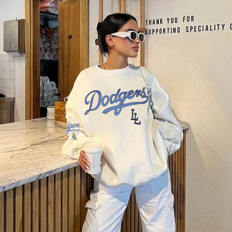 Woman wearing white loose pullover sweatshirt with Dodgers print and long sleeves