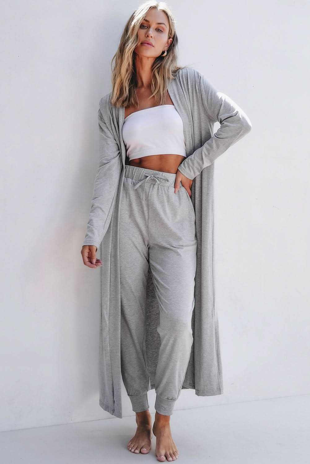 Woman wearing a gray split long cardigan and drawstring waist skinny pants lounge set with white tube top