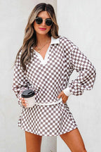 Woman wearing khaki checkered print polo collar cropped long sleeve top and drawstring mini skirt set holding coffee cup